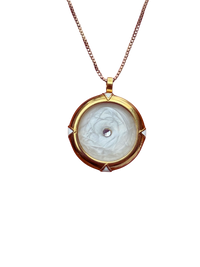 Gold pendant necklace with a white stone on a white background